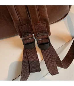 Détail des bretelles réglables en cuir marron foncé avec boucles noires résistantes