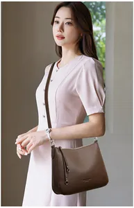 Detailed texture of brown lychee grain leather shoulder bag with silver hardware accents