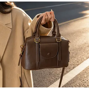 Detailed shot of dark brown Boston bag in leather with elegant gold-tone hardware