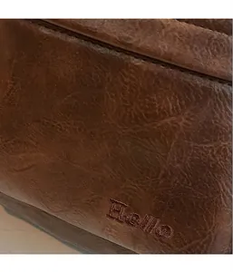 Détail d'un sac à dos vintage en cuir PU marron avec broderie Hello et fini texturé