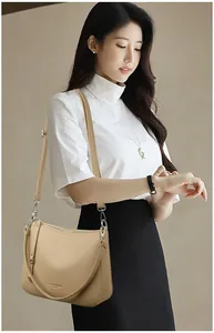 Close-up of beige lychee texture leather shoulder bag with silver hardware and logo detail