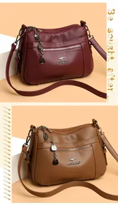 Detail of soft leather shoulder bag with lychee texture and metallic zipper compartments