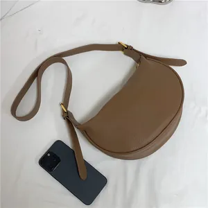 Brown lychee leather half-moon shoulder bag with adjustable strap and gold metal hardware