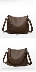 Detailed view of dark brown litchi grain leather shoulder bag with silver hardware accents