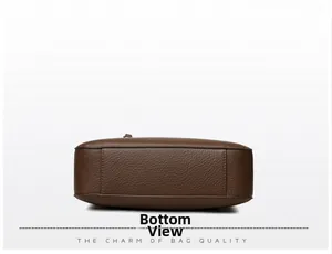 Detail view showing neat stitching and litchi texture on the bottom of the brown leather bag