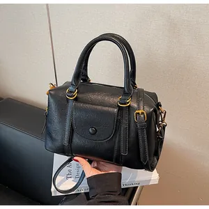 Detail of black vintage Boston bag showing PU leather texture and bronze hardware