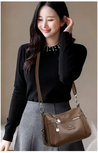 Detailed view of brown lychee grain leather crossbody bag with multiple zipper pockets