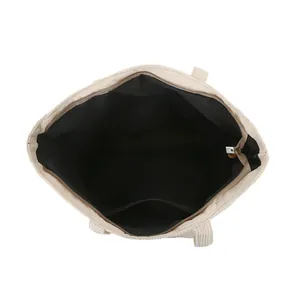 Vista dall'alto della borsa tote in velluto a coste beige con grande interno e zip