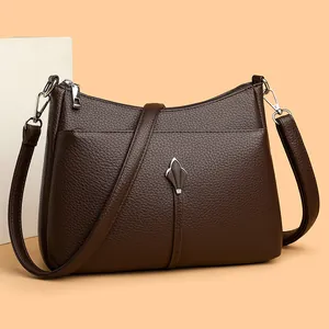 Bolso bandolera de cuero granulado marrón oscuro con adorno de escudo plateado