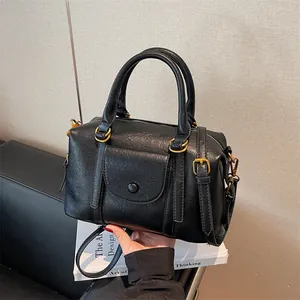 Classic black leather Boston bag with retro gold hardware and adjustable strap