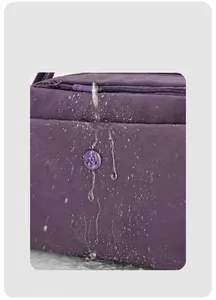 Detailansicht von wasserdichtem lila Nylongewebe mit Wassertropfen und rundem M-Logo