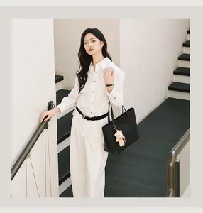 Minimalist large black tote bag for women shown in a modern urban lifestyle setting