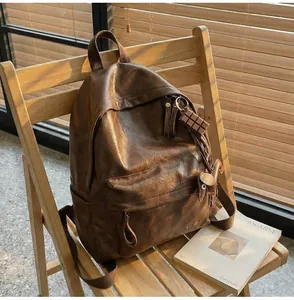 Détail d'un sac à dos vintage en cuir PU marron sur une chaise en bois ensoleillée
