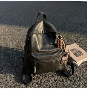 Vue détaillée du sac à dos noir en cuir PU avec texture vintage et breloques de sac