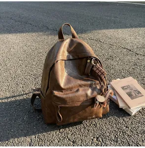 Détails du sac à dos vintage en cuir marron avec poche avant et breloques mignonnes