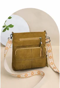 Detail of vintage green quilted bucket bag with ethnic embroidered strap and tassels