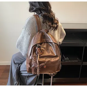 Détail du sac à dos vintage en cuir PU marron avec pendentifs chocolat et chien mignons