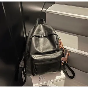 Détail du sac à dos minimaliste en similicuir noir avec imprimé Hello et breloques
