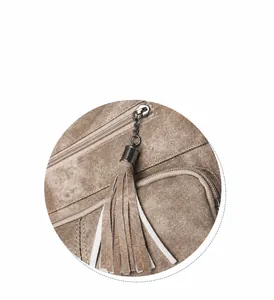 Detail of khaki tassel zipper on vintage shoulder bag showing smooth metallic hardware