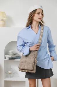 Detail of vintage brown PU leather bucket bag featuring embroidered wide strap and tassels
