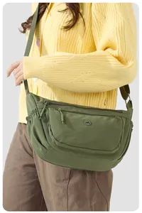 Detail der armee-grünen Nylon-Tasche mit Reißverschlussfächern und breitem Schultergurt