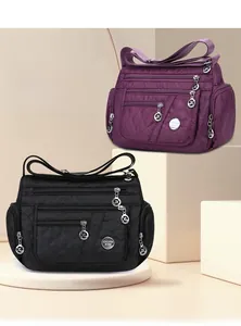 Detailed view of multi-compartment quilted nylon crossbody bags in purple and black