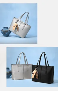 Detail of silver and black tote bags with matte texture and cute bear charm accessories