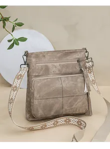 Detail of vintage quilted bucket bag featuring embroidered wide strap and tassel zipper