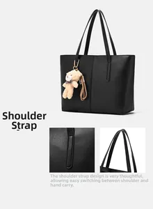 Detail of reinforced shoulder strap stitching and smooth leather finish on black tote bag