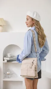 Quilted bucket bag with ethnic embroidered strap and tassel detail in beige finish
