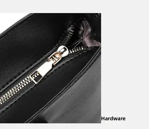 Detailed close-up of high-quality gold zipper hardware on a black textured leather tote bag
