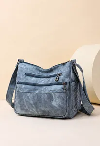 Détail du sac à bandoulière bleu vintage en toile délavée avec plusieurs poches pratiques