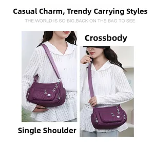 Detail view of purple quilted nylon crossbody bag showing multiple functional zipper pockets