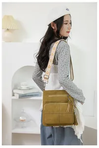 Detail of mustard yellow crossbody bag with quilted texture and ethnic strap