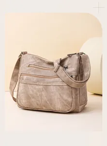 Détails du sac bandoulière en toile kaki avec plusieurs fermetures éclair et sangle