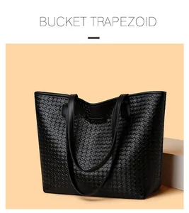 Detail view of the black trapezoid bucket bag with woven leather texture and minimalist design