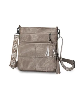Detail of vintage quilted bucket bag featuring embroidered wide strap and dual tassels