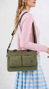Olive green nylon crossbody bag showing the adjustable strap and large side pockets