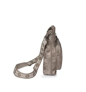 Detail of vintage brown leather bag with ethnic pattern wide strap and metal zipper