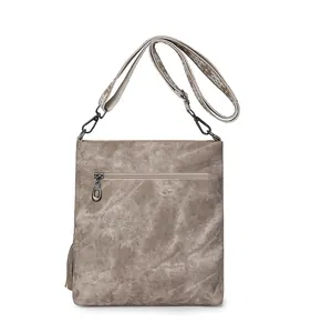 Detail of vintage crossbody bag showing textured fabric and floral embroidered strap