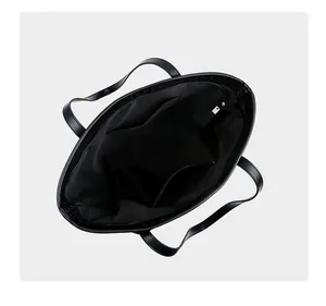 Interior view of black tote bag showing spacious main compartment and zipper pocket