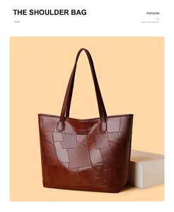 Detail of dark brown tote with embossed geometric patterns and sturdy shoulder straps