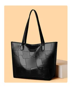 Detail showing geometric leather patchwork and embossed Sport logo on black tote bag