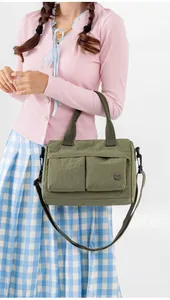 Army green nylon crossbody bag with multi-pocket design shown on shoulder by model