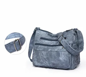 Gros plan sur la bandoulière réglable avec boucle métallique de ce sac en toile bleue