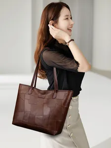 Detail shot of the dark brown patchwork tote bag featuring unique geometric leather textures