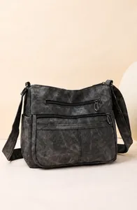 Détail du sac à bandoulière en cuir souple avec plusieurs fermetures éclair