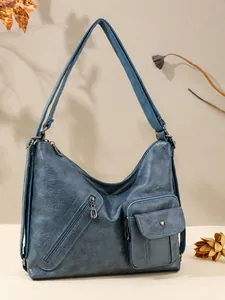 Close-up of vintage blue crossbody bag featuring multiple pockets and soft texture