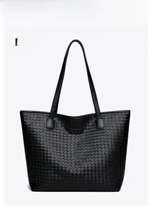Detailed front view of black woven tote bag with dual straps and square logo on white background