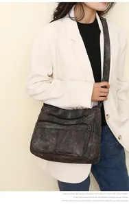 Détail du sac bandoulière rétro gris foncé avec poches zippées et texture en cuir lavé